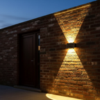 Halo solar wall light mounted on brick wall beside front door at dusk