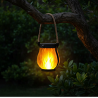 Ember solar flame lantern hanging from tree branch at night
