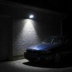 Sentry solar security light on garage wall lighting a parked car