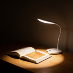 Aurevia Stem LED desk lamp lighting an open book on a wooden desk at night