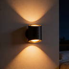 Aurevia Twin cordless LED wall sconce washing a bedroom wall with warm light from both ends at night