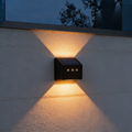 Aurevia Ledge solar fence light casting warm light up and down a rendered garden wall at night