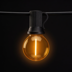 Single G40 globe bulb in its ribbed black in-line holder hanging from black rubber festoon cable on a black background