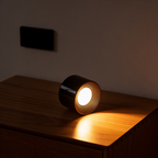 The wall light lifted off its bracket and glowing on a wooden sideboard, empty wall plate behind