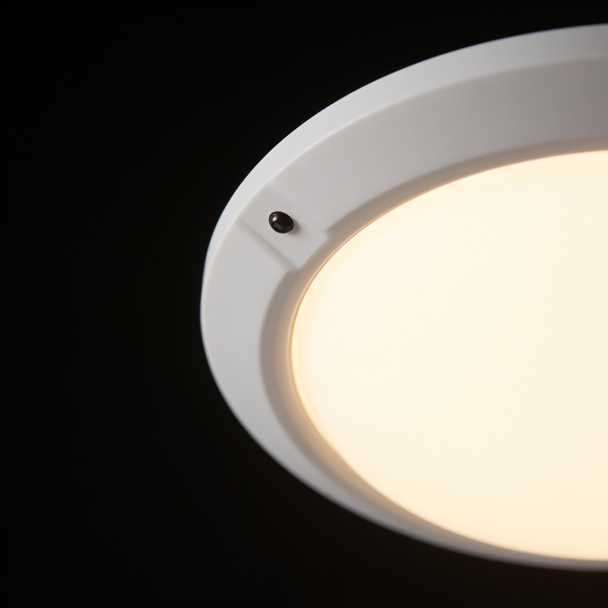 Close detail of the Orbit ceiling light's white rim and infrared sensor bead