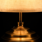 Close detail of the Linen table lamp's stepped brushed brass base