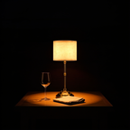 The Linen table lamp on a dining table at night beside a wine glass and folded napkin