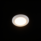 The Orbit ceiling light on a black studio background, showing its shallow white disc and stepped rim