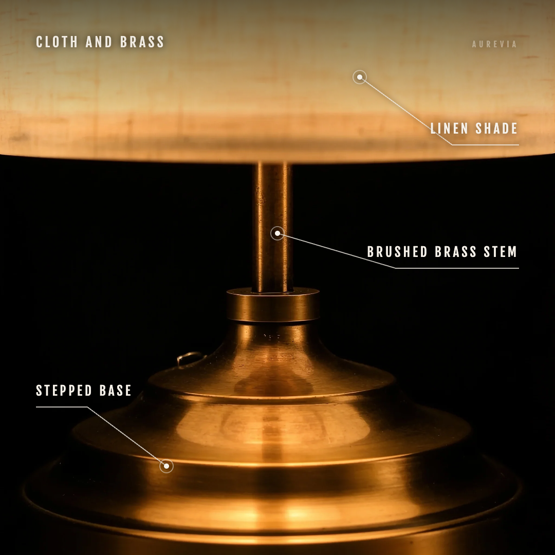 Close view of the Linen table lamp with its linen shade, brushed brass stem and stepped base labelled